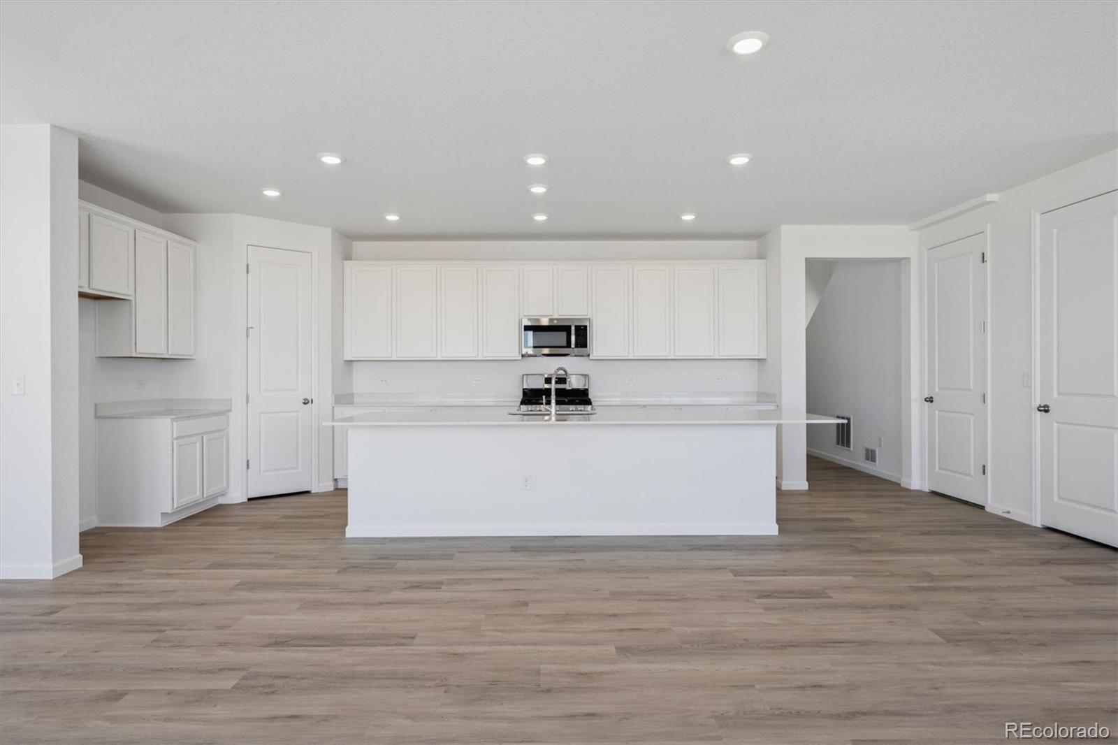 45935 Gentry Avenue Bennett, CO 80102 - Photo 10 of 22 a view of kitchen center wooden floor stainless steel appliances and cabinets