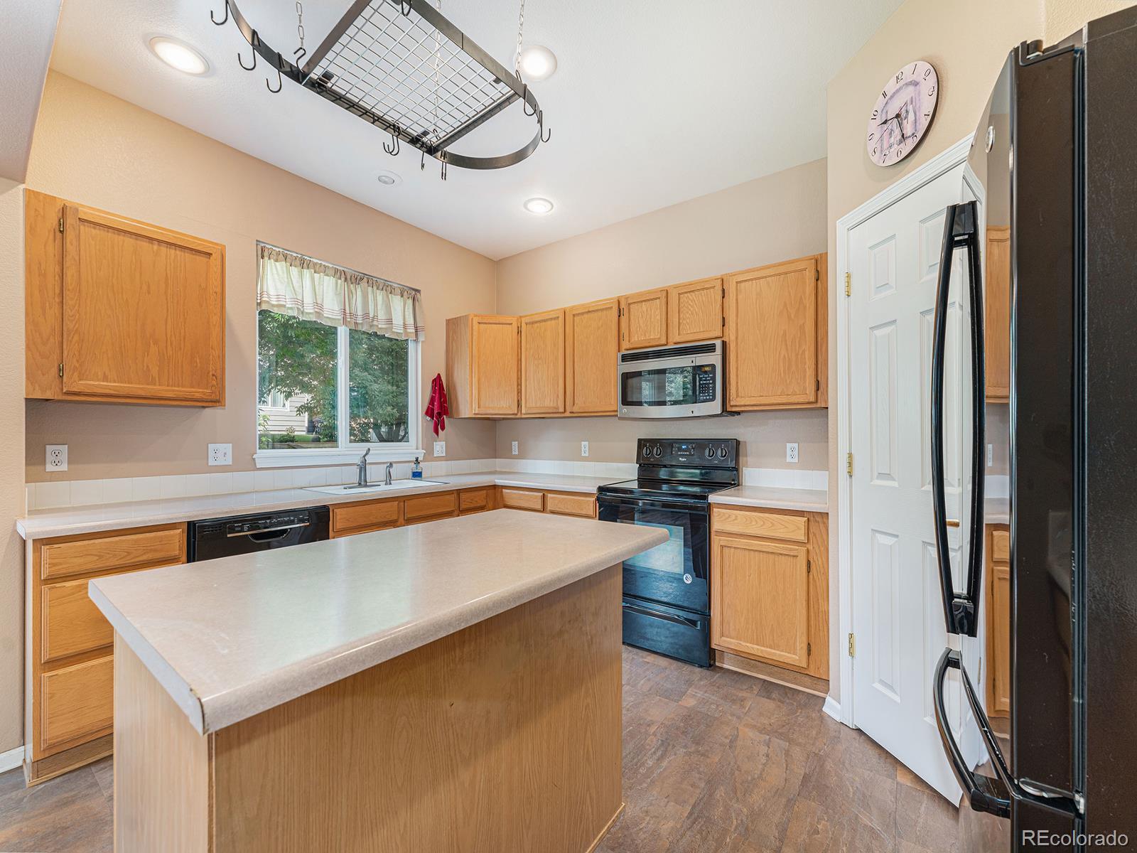 9911 Sylvestor Road Highlands Ranch, CO 80129 - Photo 12 of 31 a kitchen with stainless steel appliances granite countertop a sink a stove a refrigerator cabinets and a dining table