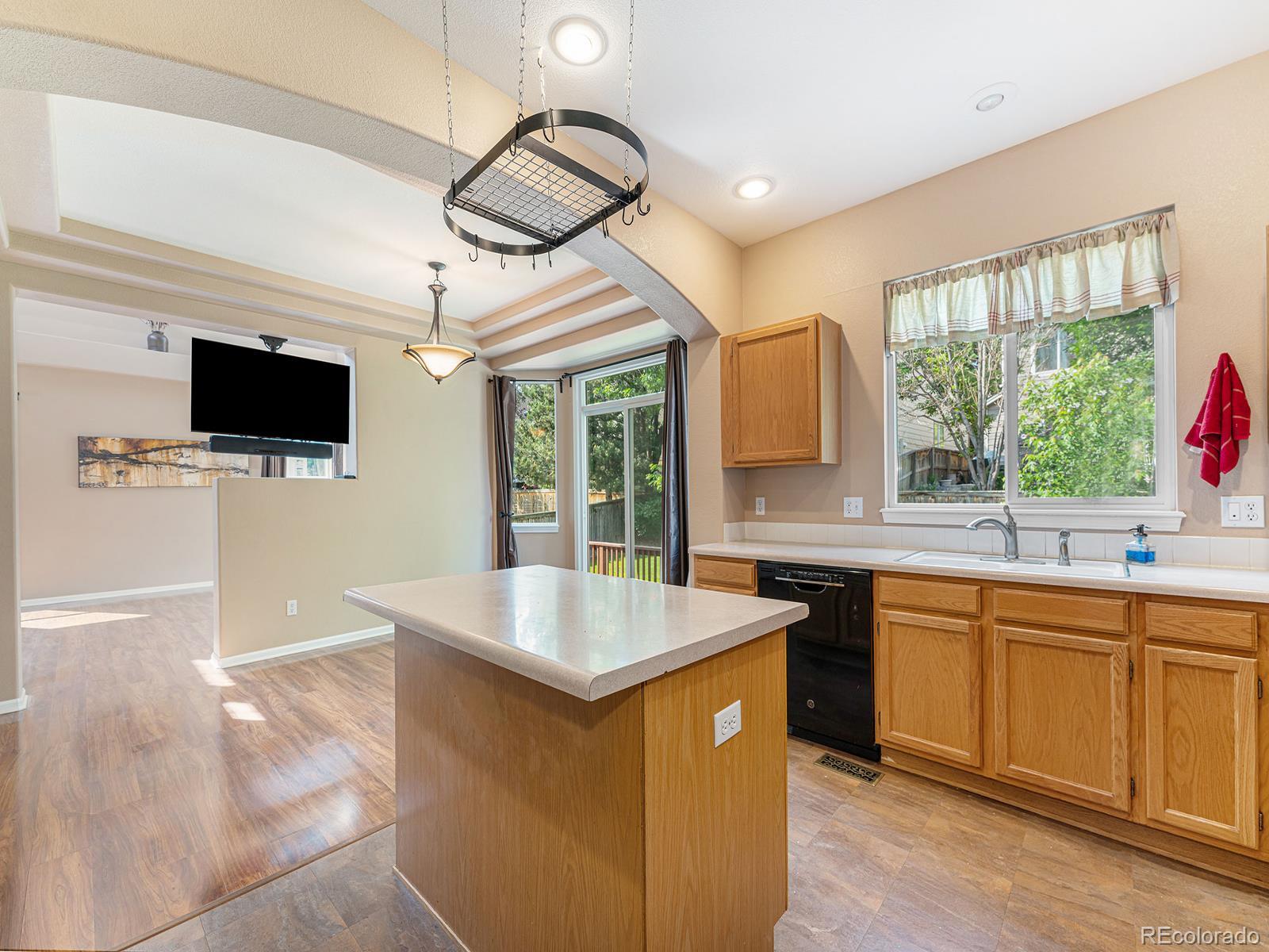 9911 Sylvestor Road Highlands Ranch, CO 80129 - Photo 14 of 31 a open kitchen with stainless steel appliances granite countertop a sink and a microwave