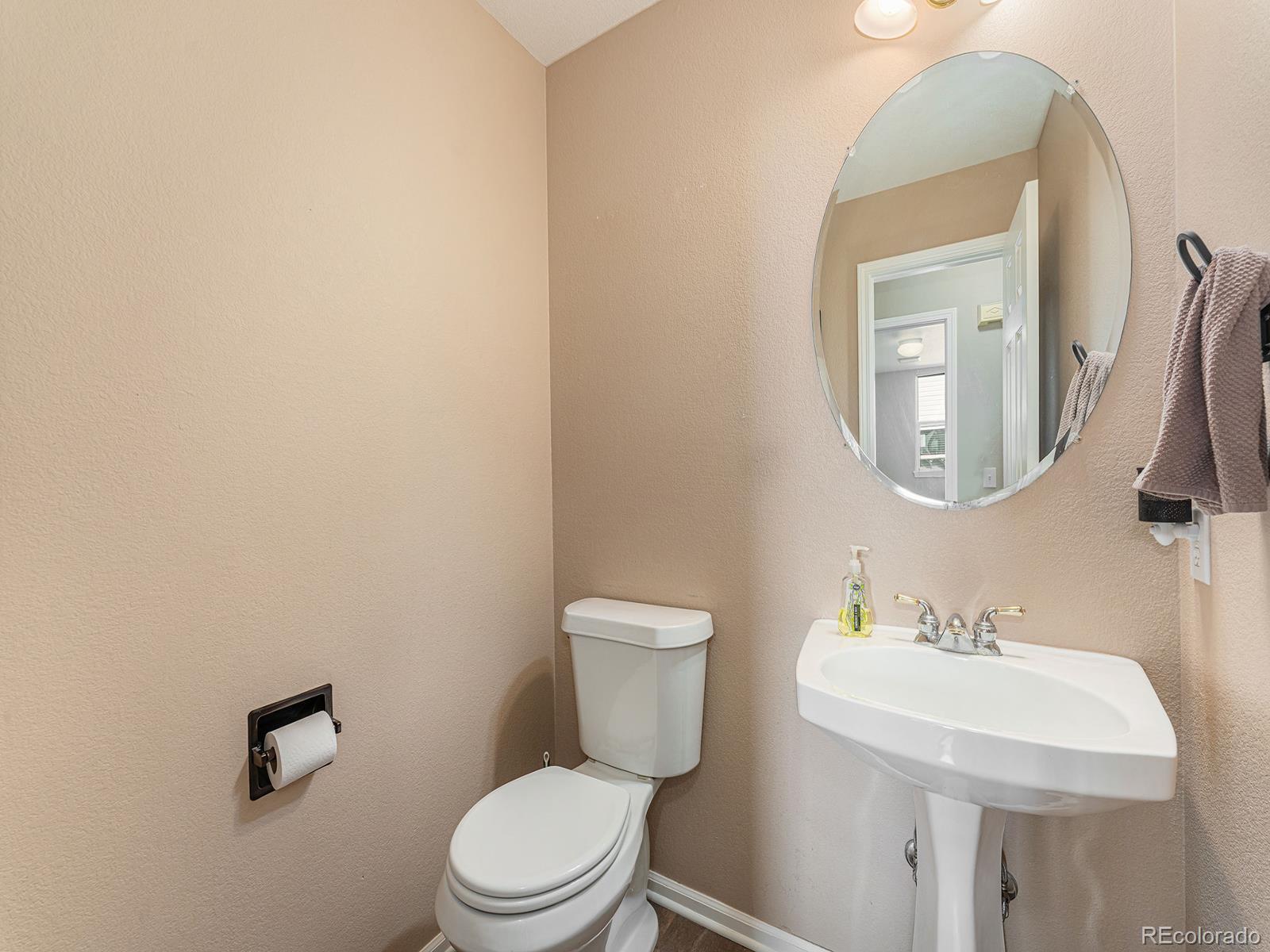 9911 Sylvestor Road Highlands Ranch, CO 80129 - Photo 15 of 31 a bathroom with a toilet a sink and mirror