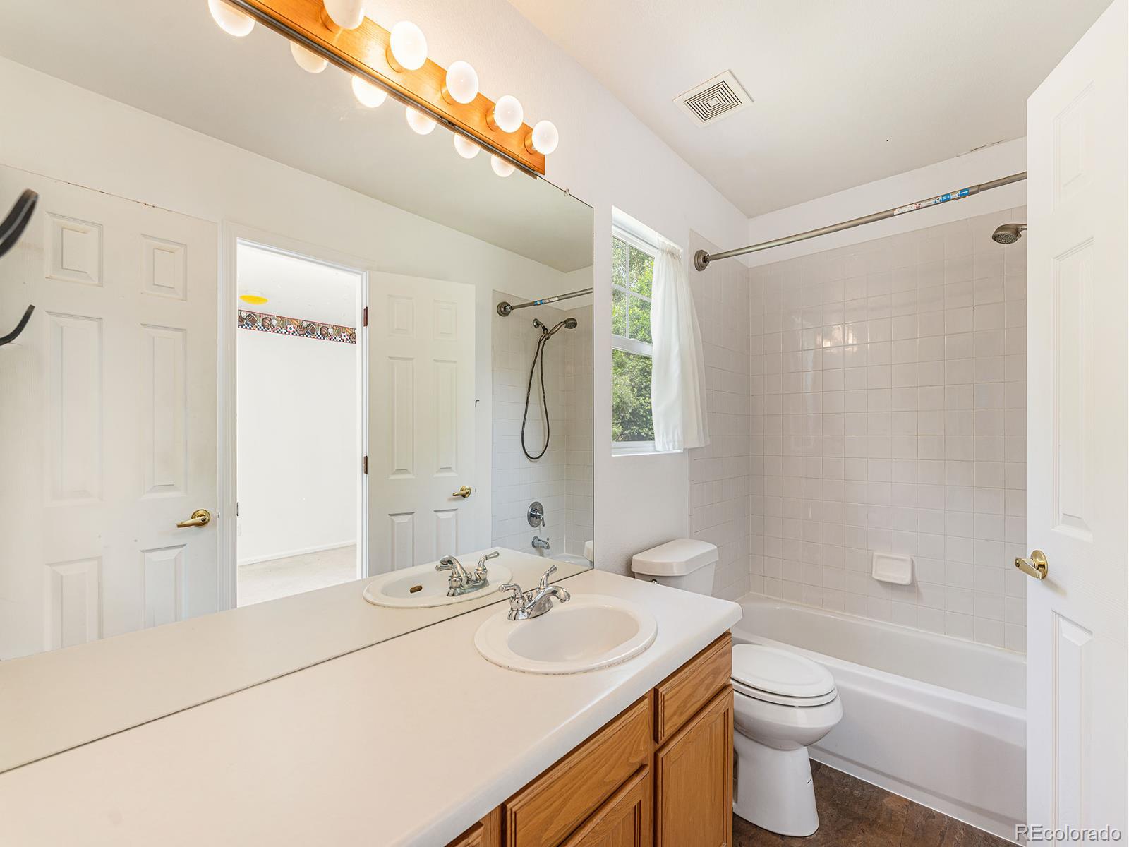 9911 Sylvestor Road Highlands Ranch, CO 80129 - Photo 21 of 31 a bathroom with a sink toilet a mirror and shower