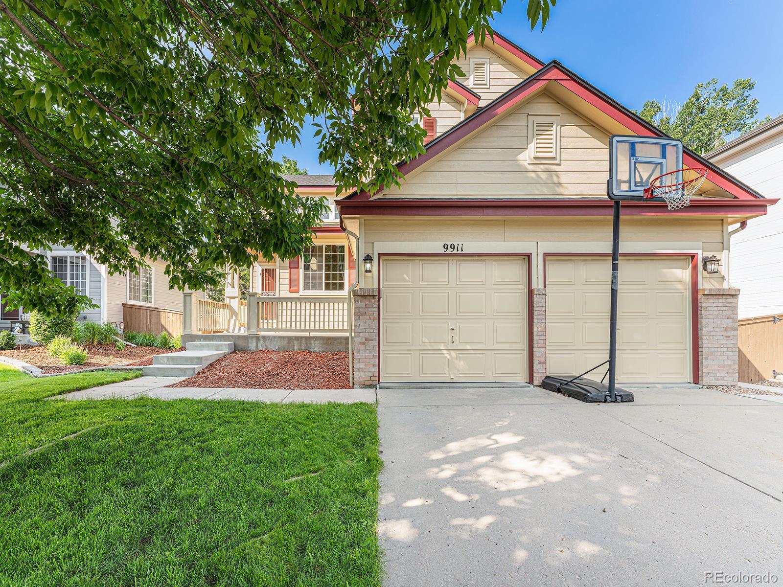 9911 Sylvestor Road Highlands Ranch, CO 80129 - Photo 3 of 31 a front view of a house with a yard and garage