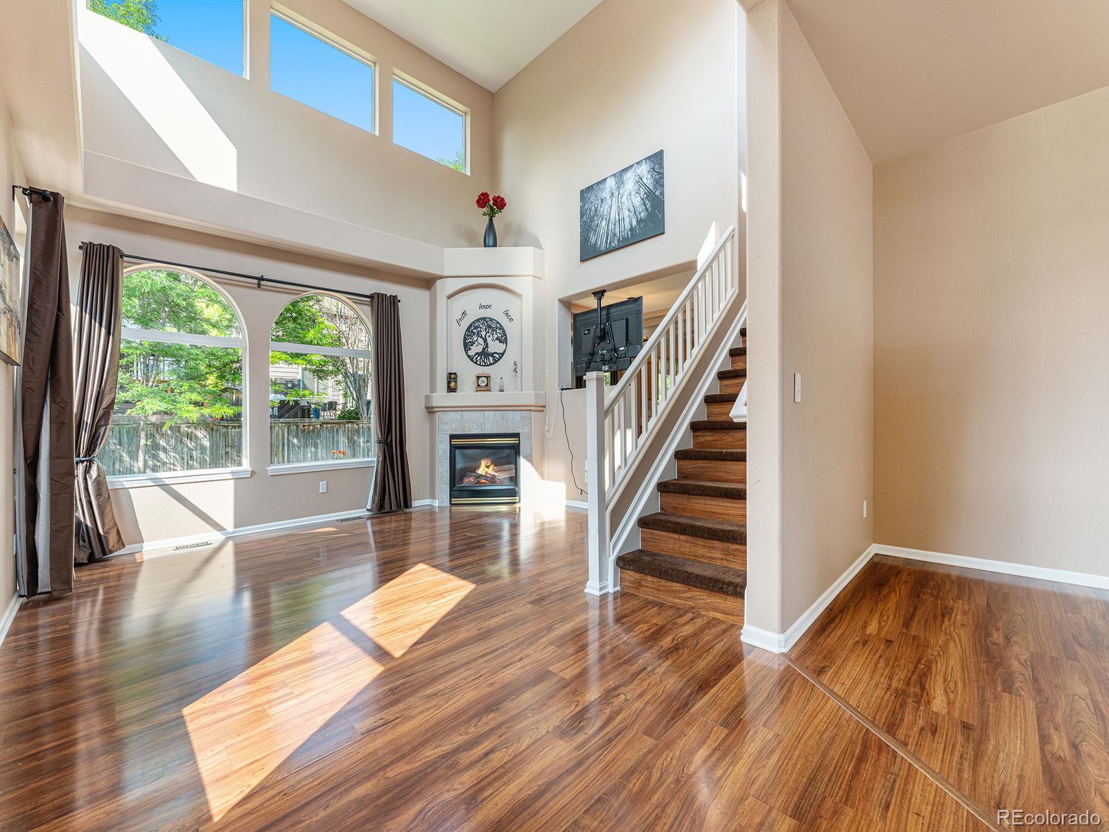 9911 Sylvestor Road Highlands Ranch, CO 80129 - Photo 4 of 31 a living room with wooden floor furniture and a large window
