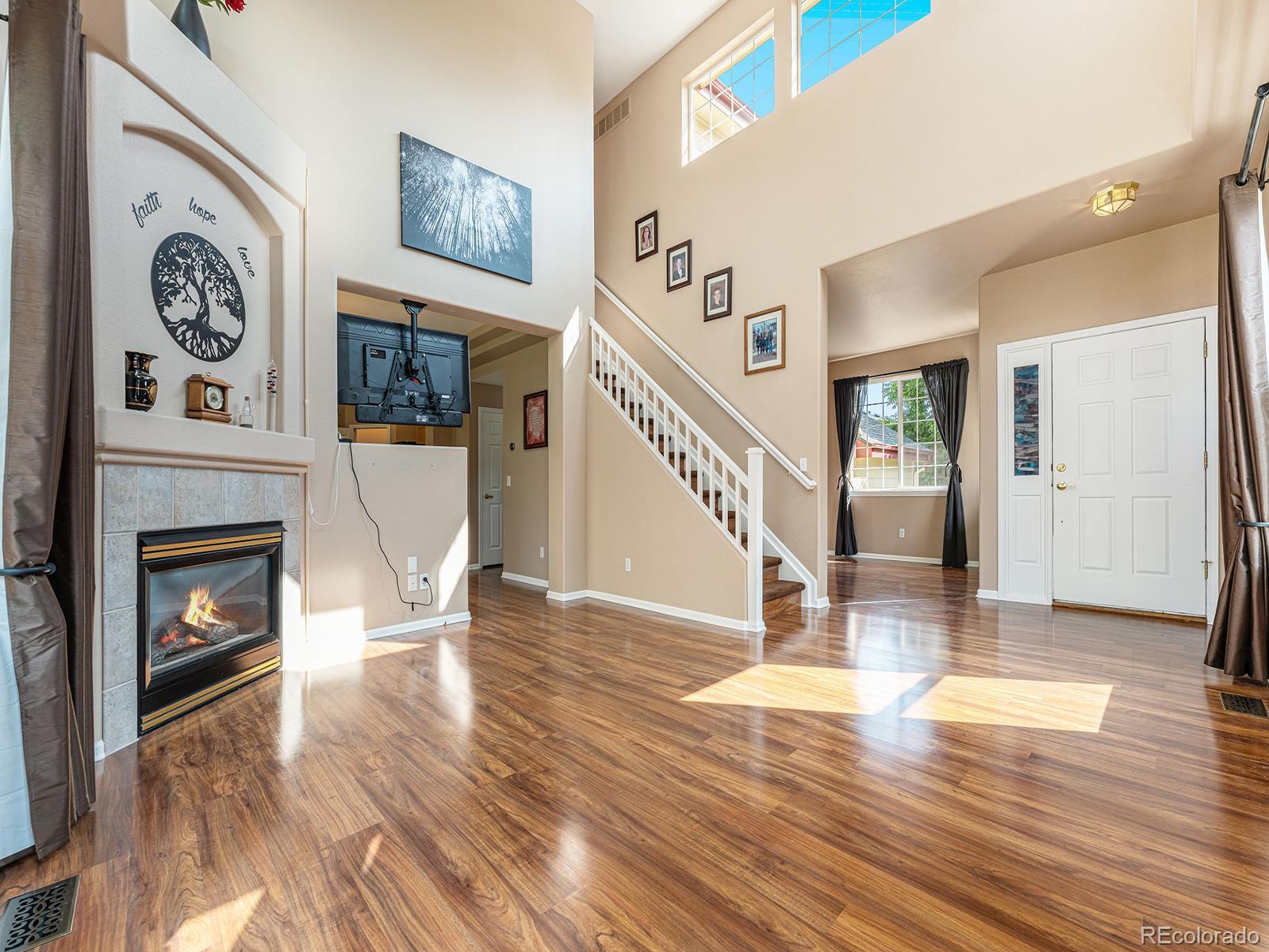 9911 Sylvestor Road Highlands Ranch, CO 80129 - Photo 5 of 31 a living room with wooden floor and a fireplace