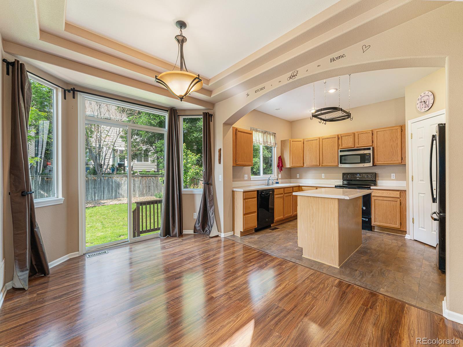 9911 Sylvestor Road Highlands Ranch, CO 80129 - Photo 9 of 31 a kitchen with stainless steel appliances granite countertop a refrigerator a sink dishwasher a stove and white countertops with wooden floor