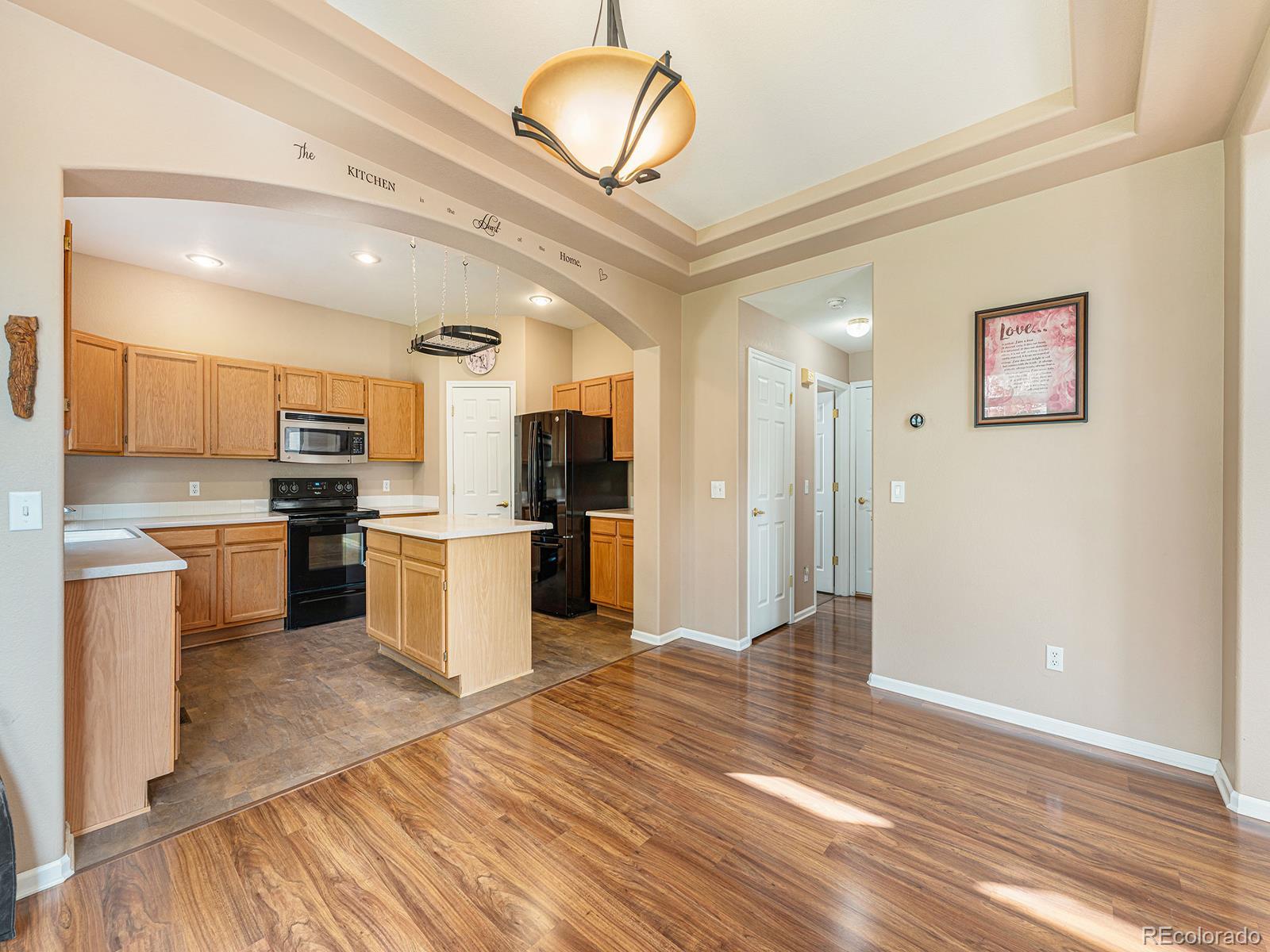 9911 Sylvestor Road Highlands Ranch, CO 80129 - Photo 10 of 31 a kitchen with granite countertop a refrigerator and a stove top oven