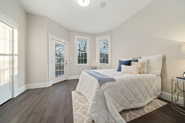 a bedroom with a large bed and wooden floor