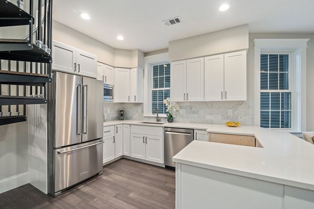 a kitchen with stainless steel appliances a refrigerator sink and cabinets
