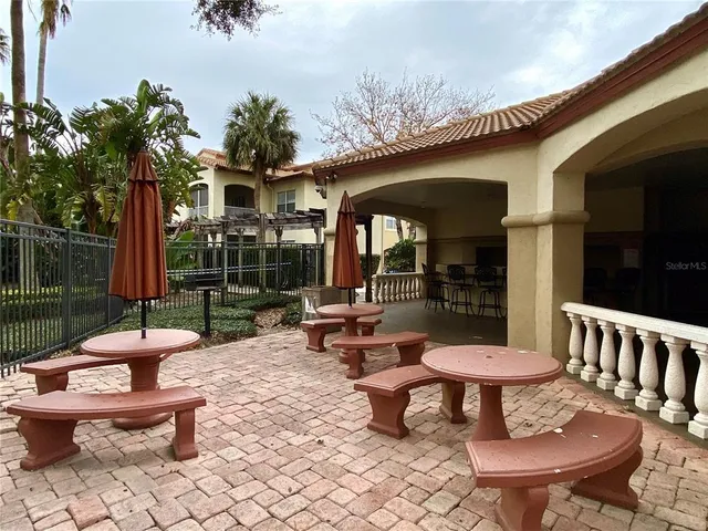 a view of a patio with a dining table and chairs with a potted plants and a table
