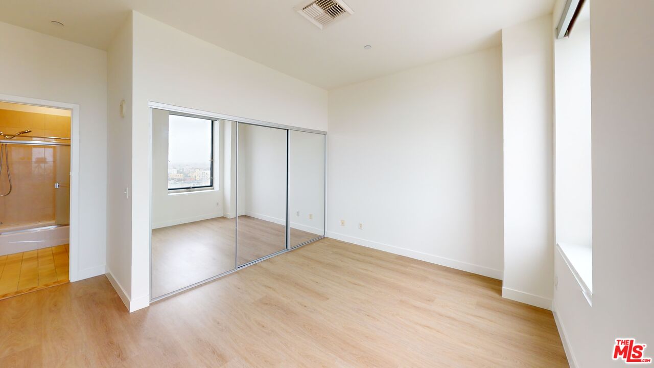 3810 Wilshire Boulevard, Unit 1108 Los Angeles, CA 90010 - Photo 12 of 15 a view of an empty room with wooden floor