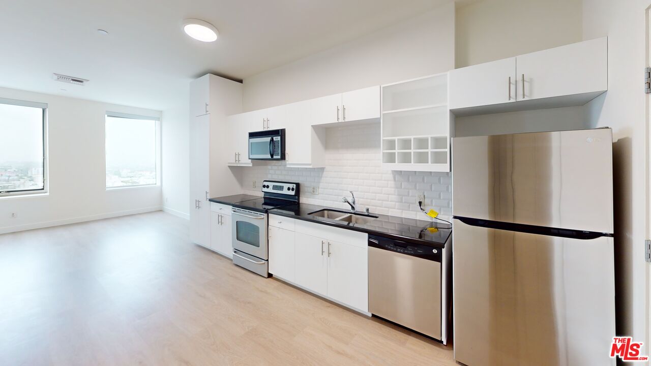 3810 Wilshire Boulevard, Unit 1108 Los Angeles, CA 90010 - Photo 2 of 15 a kitchen with stainless steel appliances a refrigerator sink and microwave