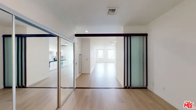 a view of empty room with wooden floor