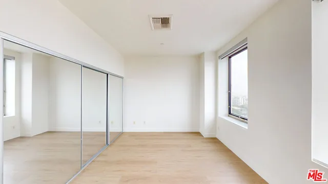 an empty room with windows and closet