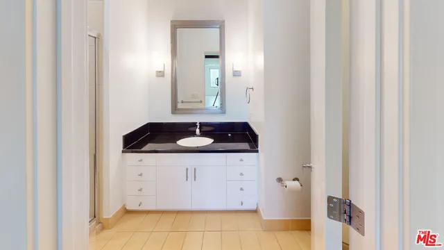 a bathroom with a granite countertop sink and a mirror