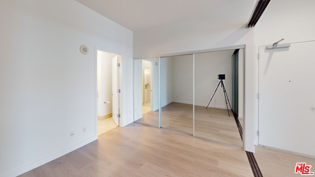 3810 Wilshire Boulevard, Unit 1108 Los Angeles, CA 90010 - Photo 9 of 15 a view of a livingroom with wooden floor and a ceiling fan