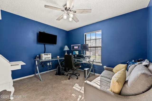 a view of a livingroom with workspace and a window