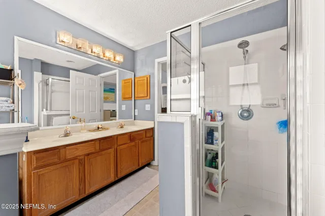 a bathroom with a double vanity sink mirror and shower