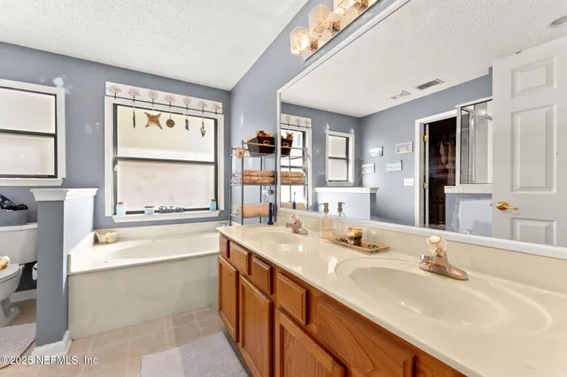 a bathroom with a granite countertop sink and a large mirror