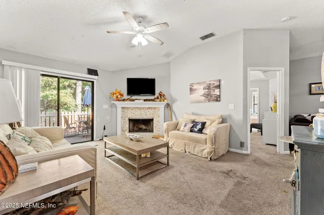 a living room with furniture a fireplace and a flat screen tv