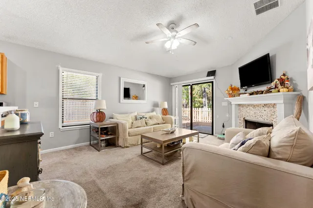 a living room with furniture a flat screen tv and a window