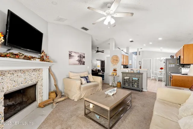 a living room with furniture a flat screen tv and a fireplace