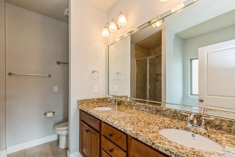 169 Windchime Way Freeport, FL 32439 - Photo 30 of 67 a bathroom with a granite countertop sink toilet and shower