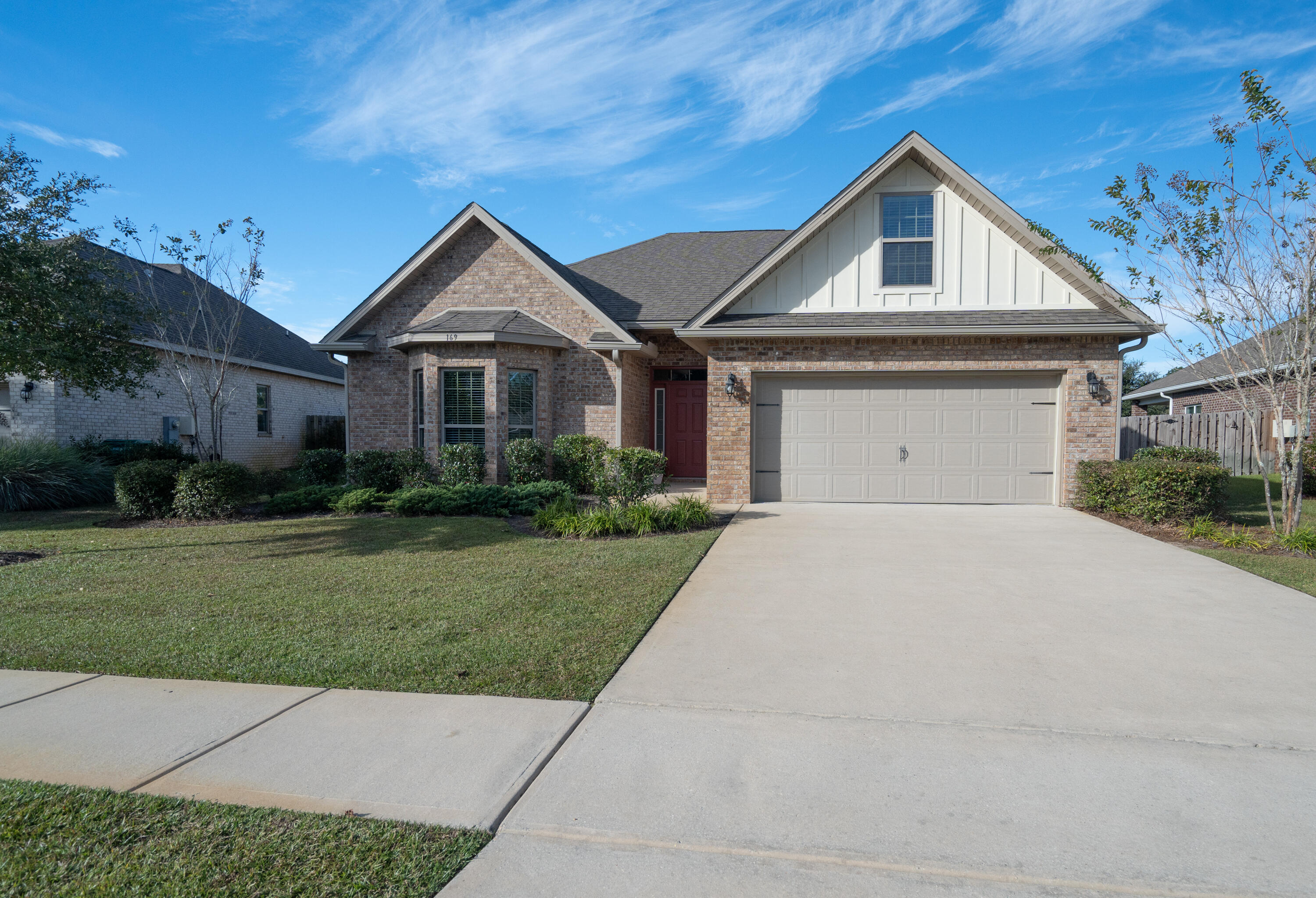 169 Windchime Way Freeport, FL 32439 - Photo 43 of 67 a front view of a house with a yard and garage