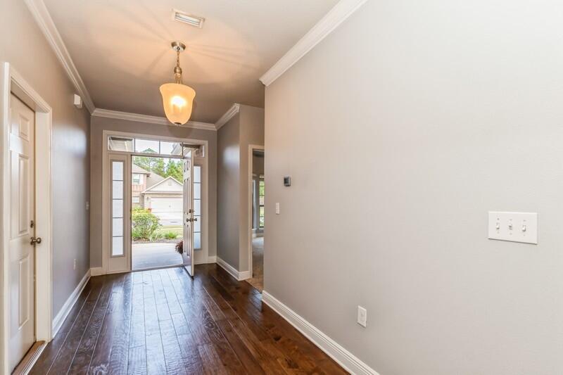 169 Windchime Way Freeport, FL 32439 - Photo 8 of 67 a view of a hallway with wooden floor and a chandelier