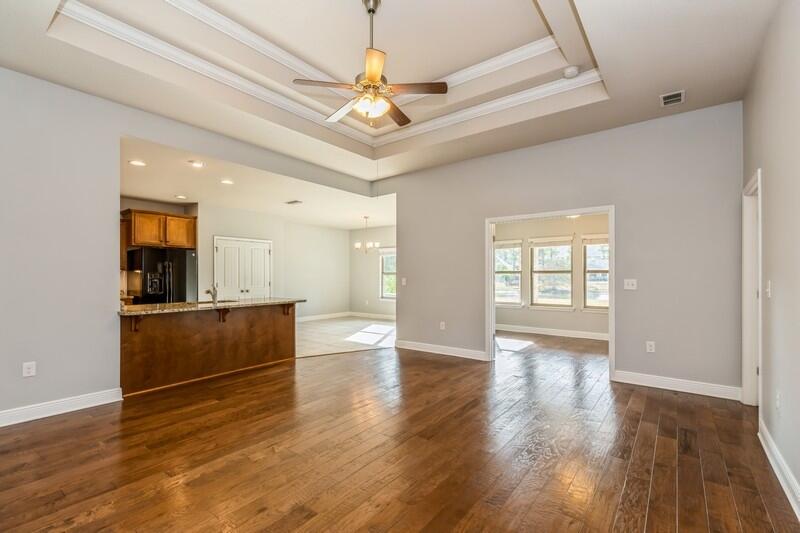 169 Windchime Way Freeport, FL 32439 - Photo 10 of 67 a view of an empty room with wooden floor and a window