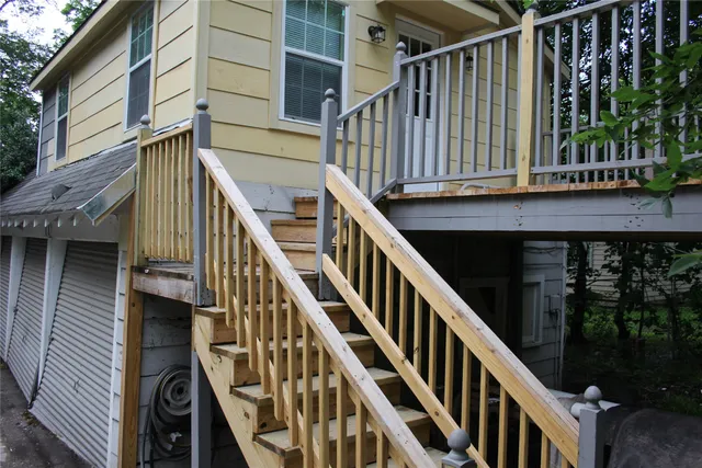 a view of staircase with railing and white walls