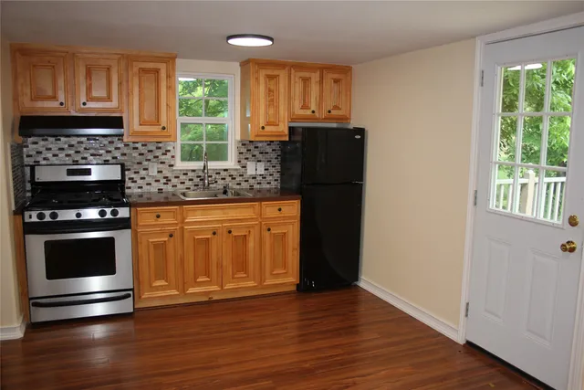 a kitchen with granite countertop wooden floors and stainless steel appliances