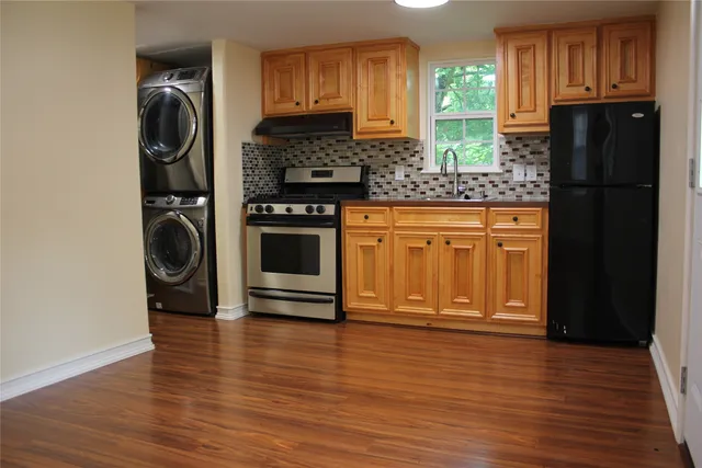 a kitchen with stainless steel appliances granite countertop a refrigerator and a stove top oven