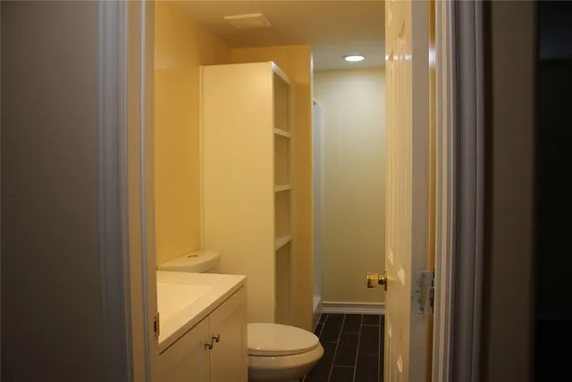 a bathroom with a granite countertop sink a toilet and shower