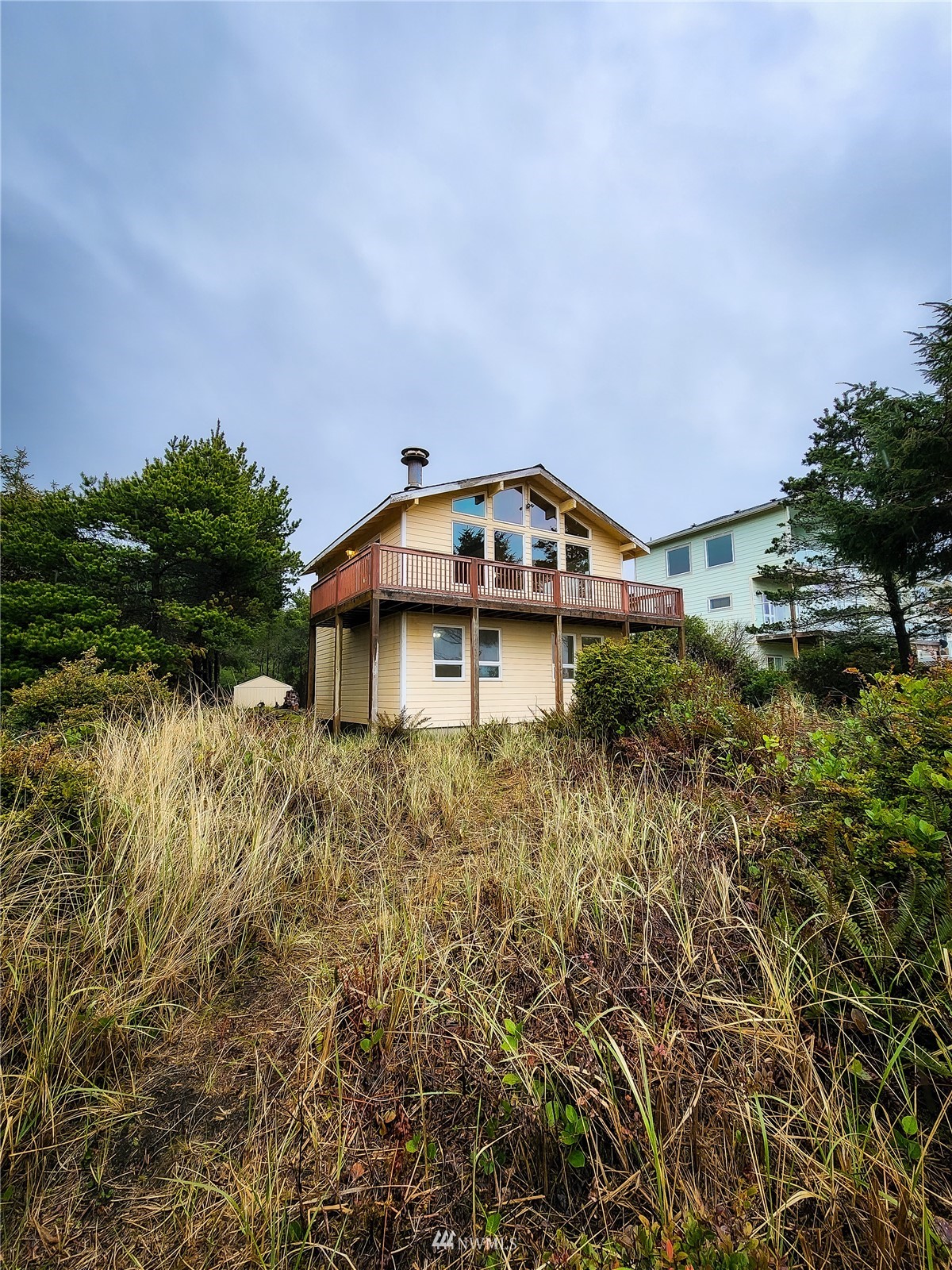 39 Ocean Lane Copalis Beach, WA 98535 - Photo 2 of 21 a backyard of a house with lots of green space