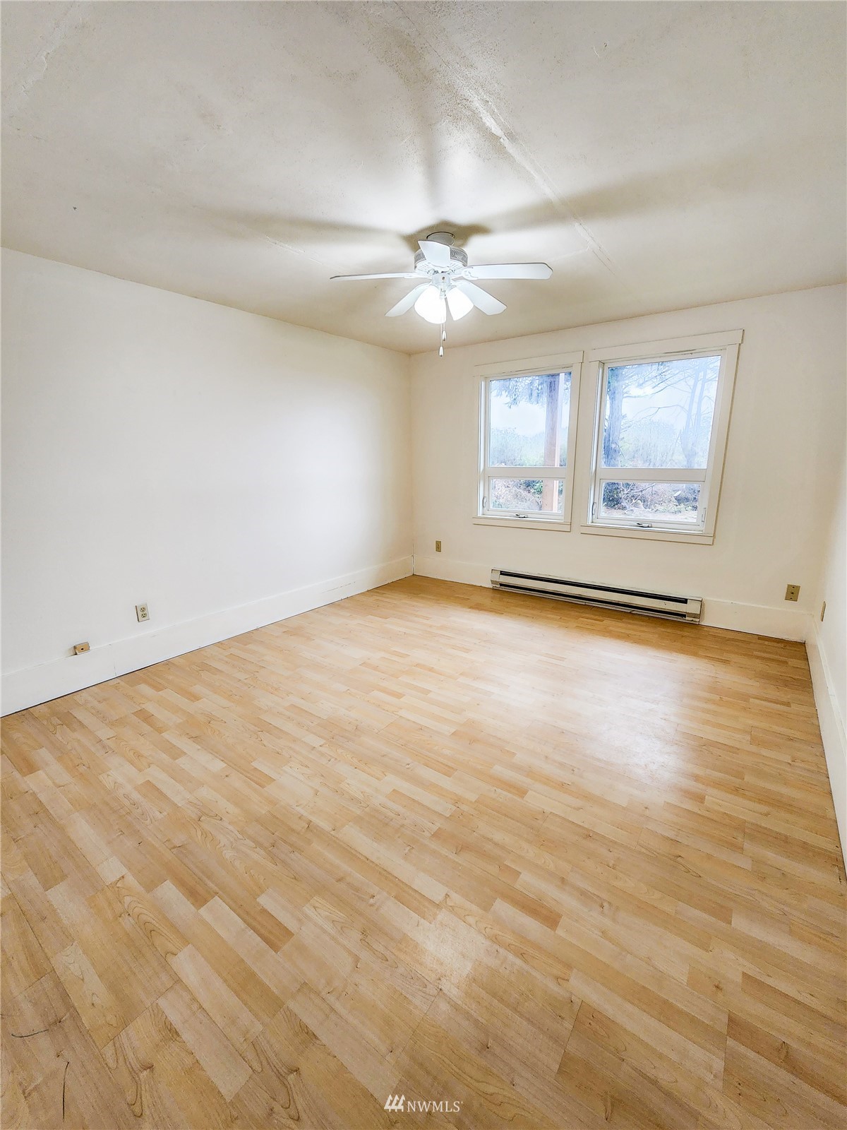 39 Ocean Lane Copalis Beach, WA 98535 - Photo 5 of 21 an empty room with wooden floor ceiling fan and windows