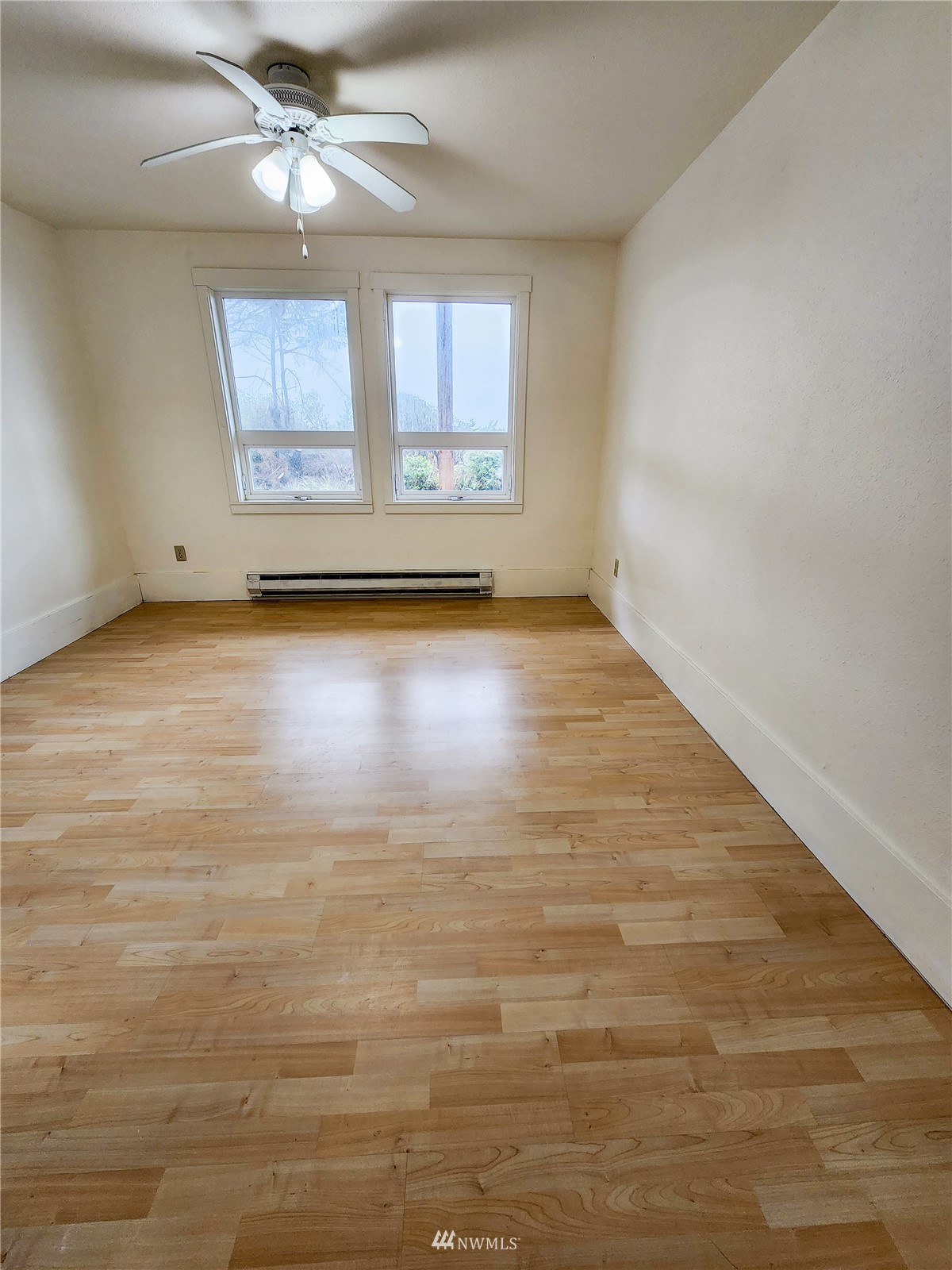 39 Ocean Lane Copalis Beach, WA 98535 - Photo 9 of 21 an empty room with chandelier fan and windows