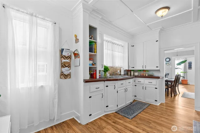 a large white kitchen with stainless steel appliances granite countertop a refrigerator and a sink