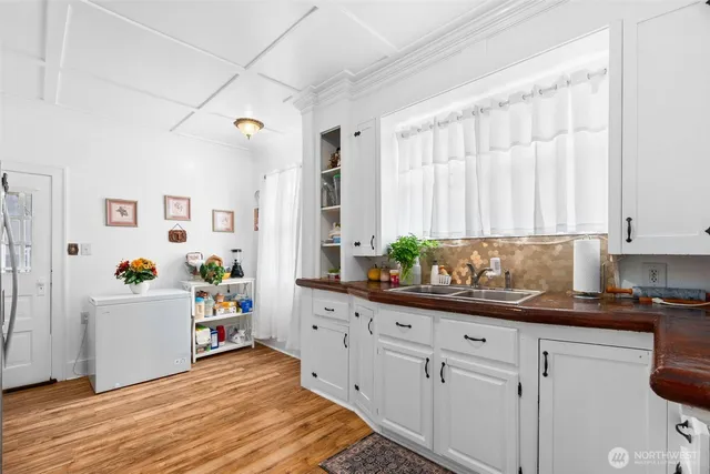 a kitchen with granite countertop a white cabinets stainless steel appliances and a window