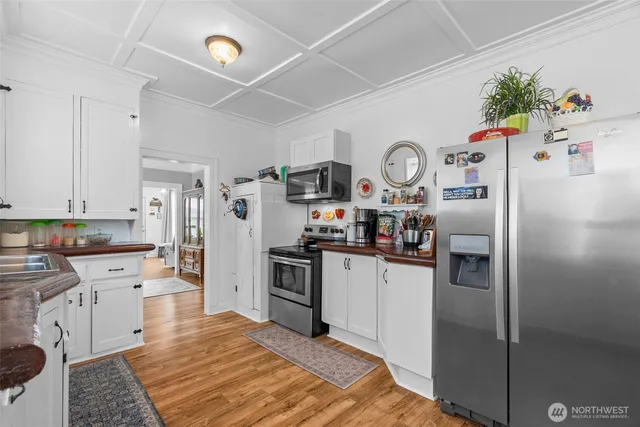 a kitchen with stainless steel appliances a refrigerator sink and wooden floor