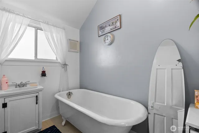 a bathroom with a tub a sink and a window