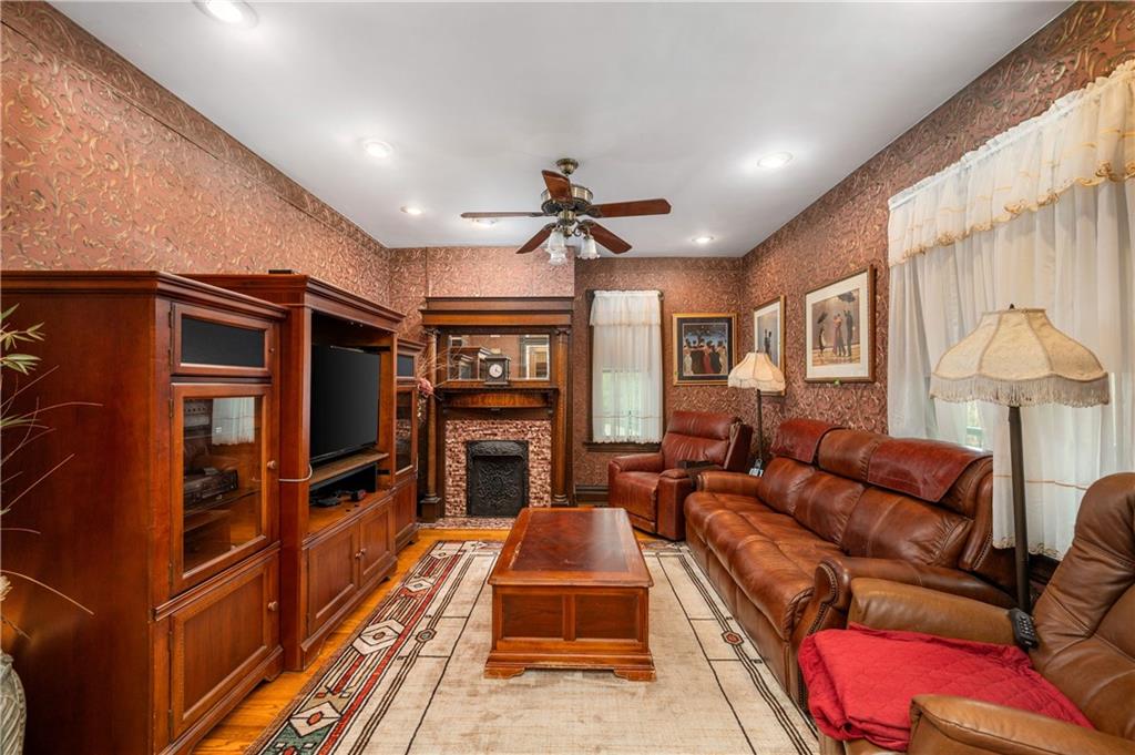 227 Aggas Road West Sunbury, PA 16061 - Photo 28 of 50 a living room with furniture a fireplace and a flat screen tv