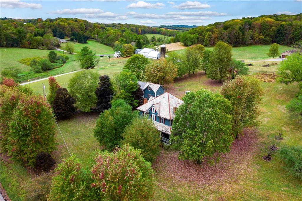 227 Aggas Road West Sunbury, PA 16061 - Photo 8 of 50 an aerial view of green landscape with trees houses and mountain view