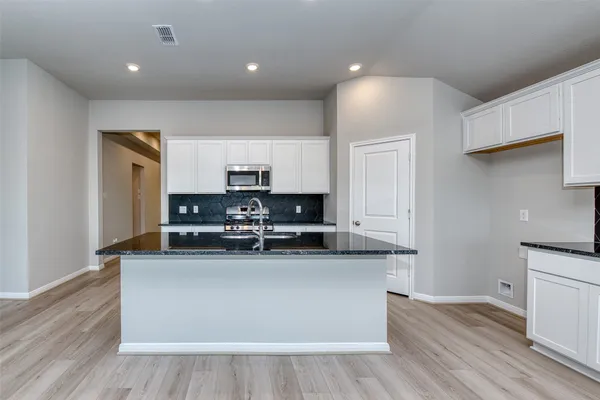 a kitchen with stainless steel appliances granite countertop a stove a sink and a refrigerator
