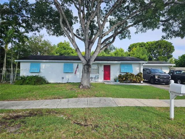 a front view of a house with a garden and trees