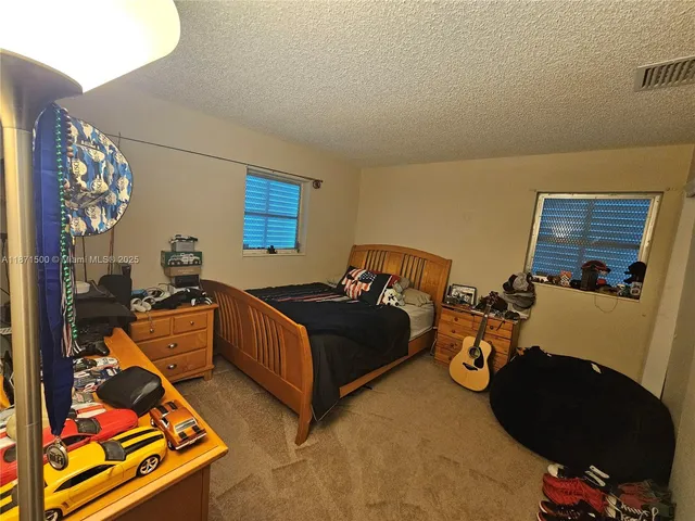 a bathroom with a double vanity sink a toilet a mirror and shower