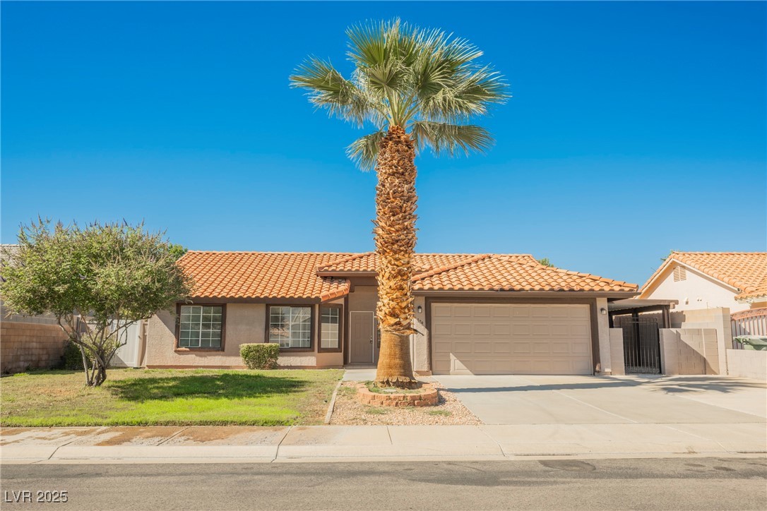 Mediterranean / spanish-style house featuring concrete driveway, stucco siding, a tile roof, and an attached garage
