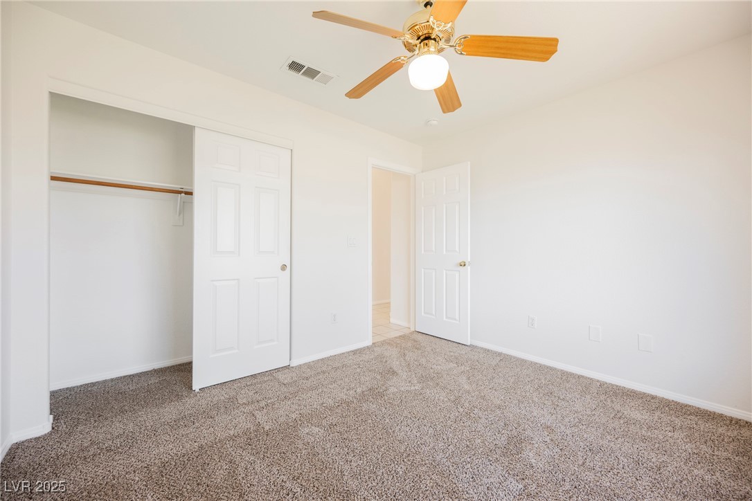 179 Grayce Mesquite, NV 89027 - Photo 12 of 25 Unfurnished bedroom with carpet floors, a closet, and a ceiling fan