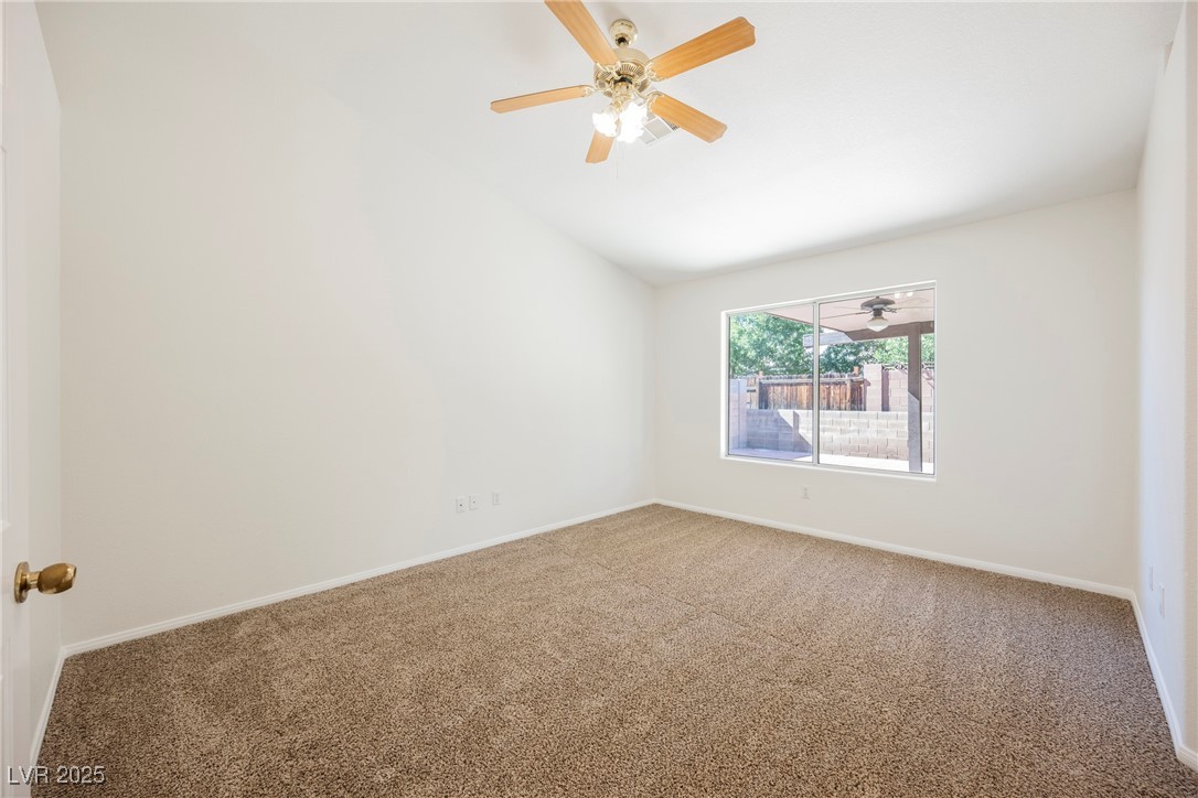179 Grayce Mesquite, NV 89027 - Photo 5 of 25 Unfurnished room featuring lofted ceiling, carpet, and a ceiling fan