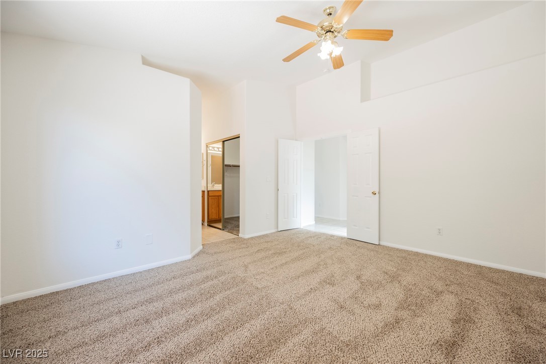 179 Grayce Mesquite, NV 89027 - Photo 7 of 25 Unfurnished bedroom featuring carpet floors, ensuite bath, a ceiling fan, and a high ceiling