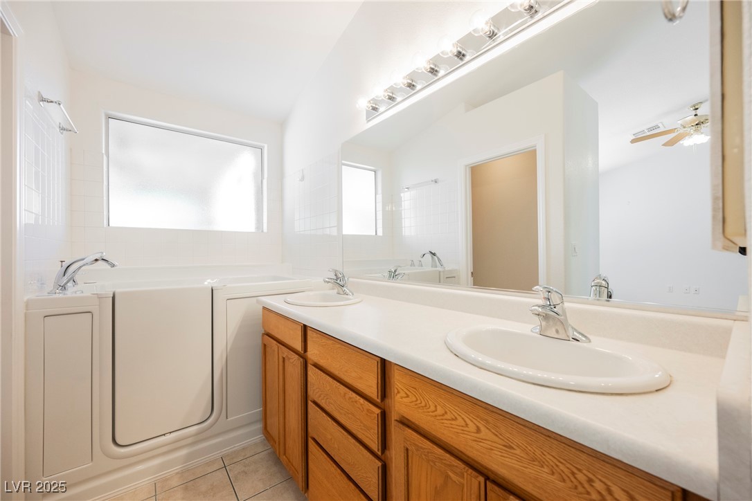 179 Grayce Mesquite, NV 89027 - Photo 8 of 25 Bathroom featuring double vanity, light tile patterned floors, a bath, and ceiling fan